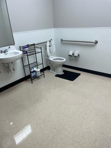 A clean commercial restroom with a shining sink and freshly cleaned floor.