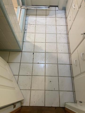 A bright white bathroom floor, freshly cleaned during a deep cleaning.