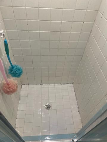 A tile shower with clean walls and floor after a deep cleaning.