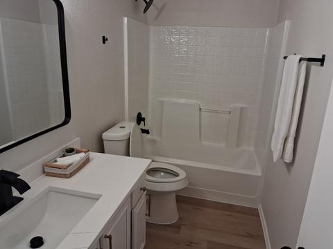 A bright bathroom with a clean vanity, toilet and tub after a move-in cleaning.