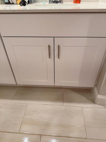 White cabinet fronts wiped down, with the floor clean right along the base.