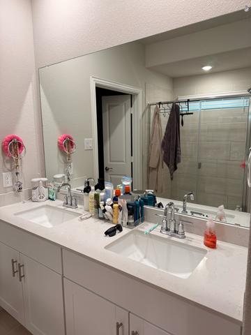 A double-sink vanity with clean counters and a shining mirror.