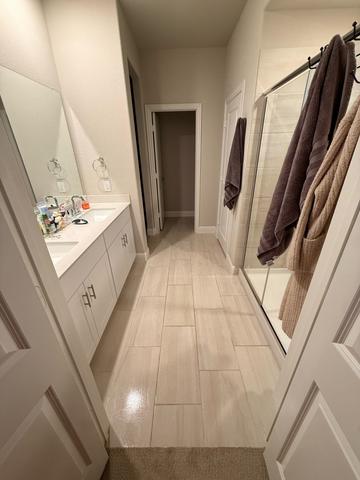 A primary bathroom hallway with freshly cleaned floors after a move-in cleaning.