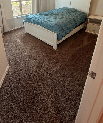 A bedroom with freshly vacuumed carpet after a move-out cleaning.