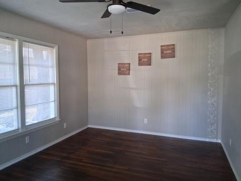 An empty bedroom with a clean floor and bright window after a move-out cleaning.