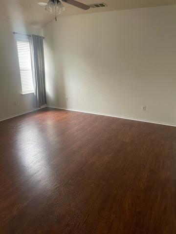 An empty bedroom with clean wood-look floors after a move-out cleaning.