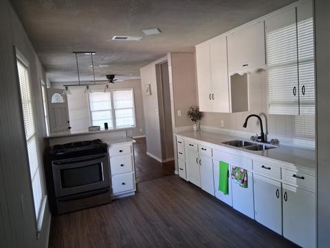 An empty kitchen with clean counters, cabinets and floors after a move-out cleaning.
