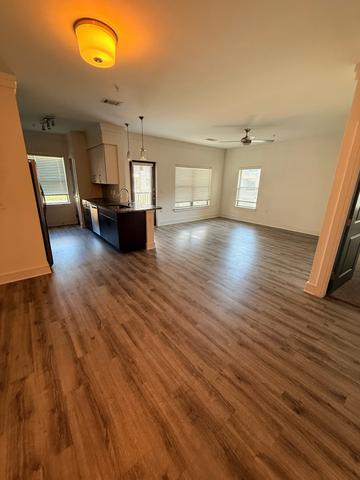 An empty living area with clean wood-look floors.
