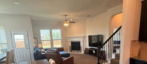 An open living area with a fireplace and staircase after a move-out cleaning.
