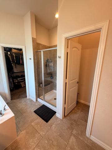 A primary bathroom shower next to the closet doorway after a move-out cleaning.