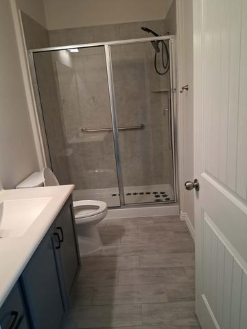 A clear, streak-free glass shower door after a move-out cleaning.