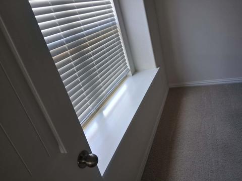 Dusted window blinds above a wiped-down window sill.
