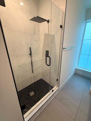 A glass shower in the middle of being cleaned.