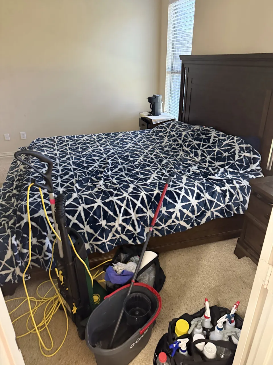 DURING: bedroom with Famous Pink Cleaning vacuum and supply caddies mid-clean