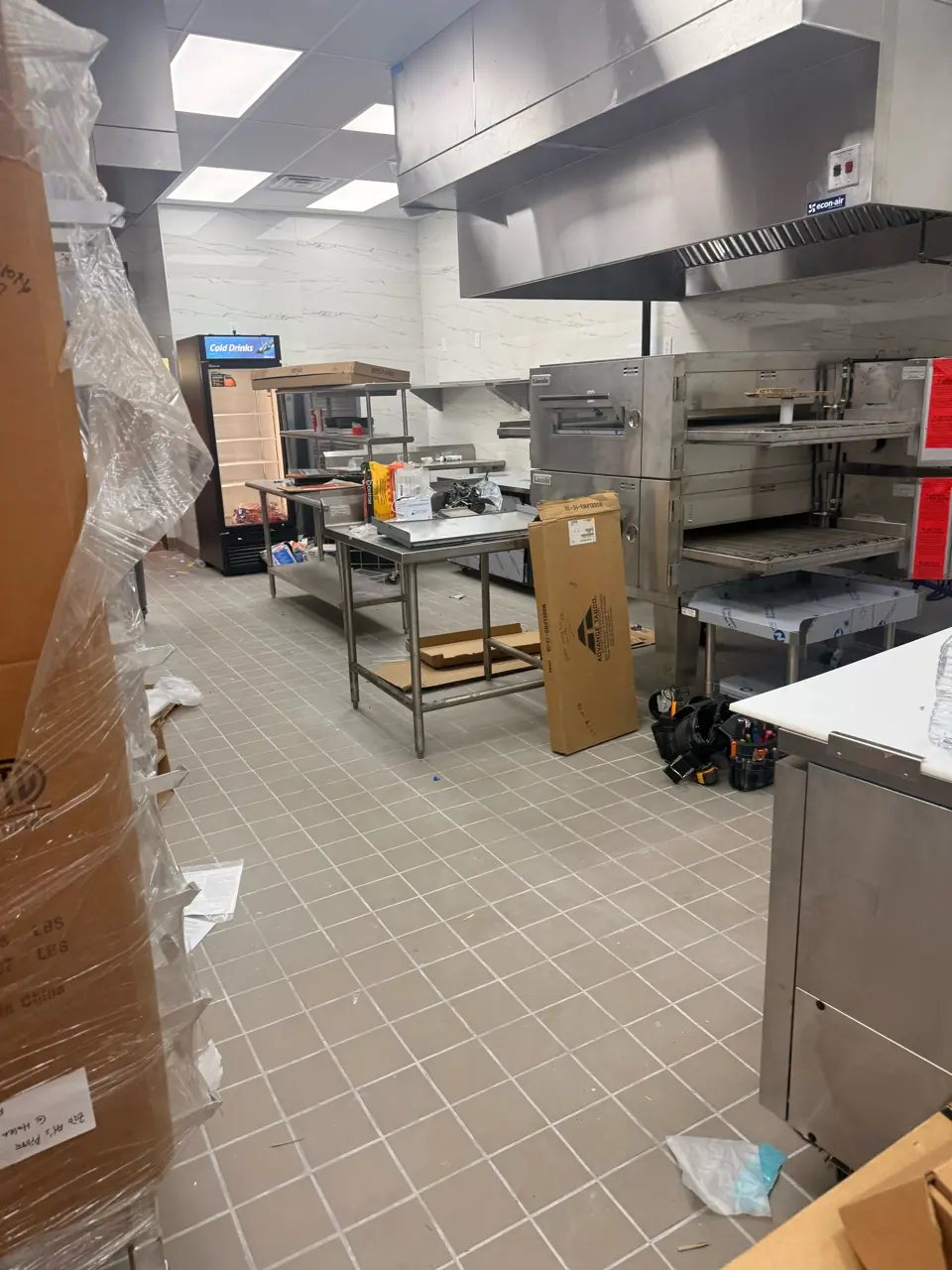 BEFORE: commercial kitchen with packaging and construction debris before post-construction cleaning